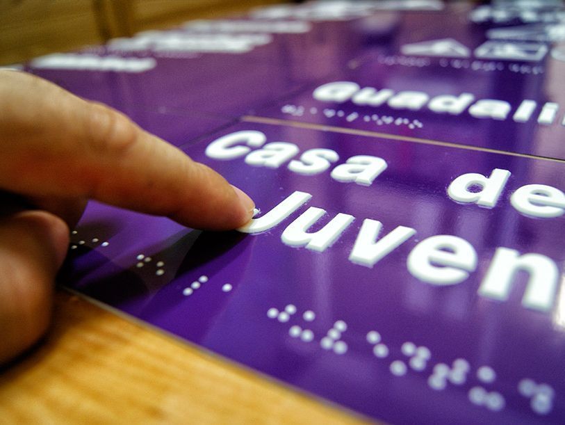 Una persona señala un cartel que dice casa de menores.