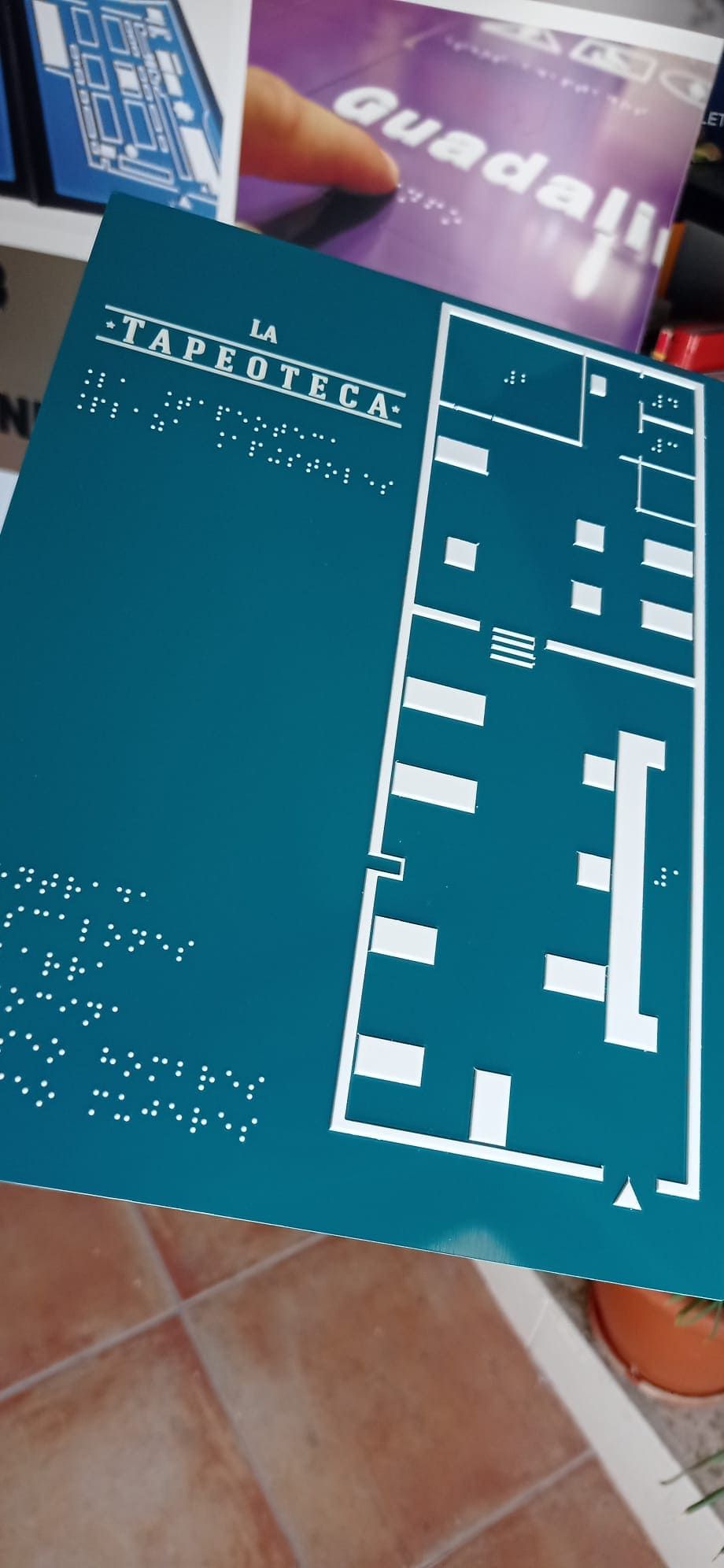 Un mapa en braille de un edificio está sobre una mesa.