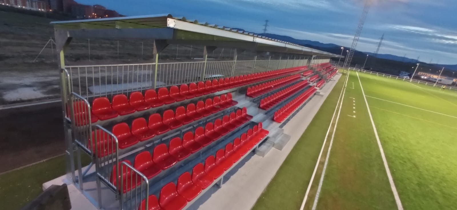 Una vista aérea de un estadio de fútbol con asientos rojos.