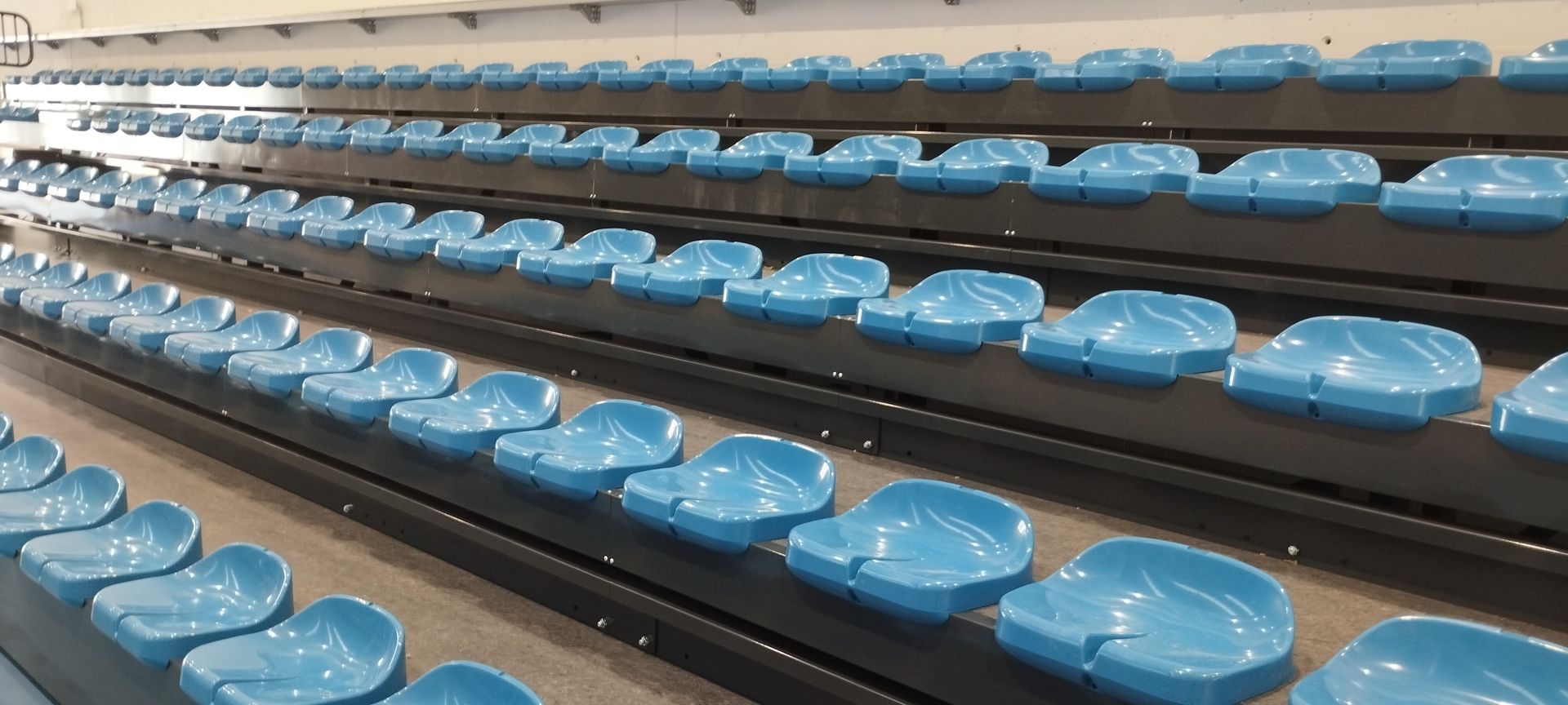 Una fila de asientos de plástico azul en un estadio.
