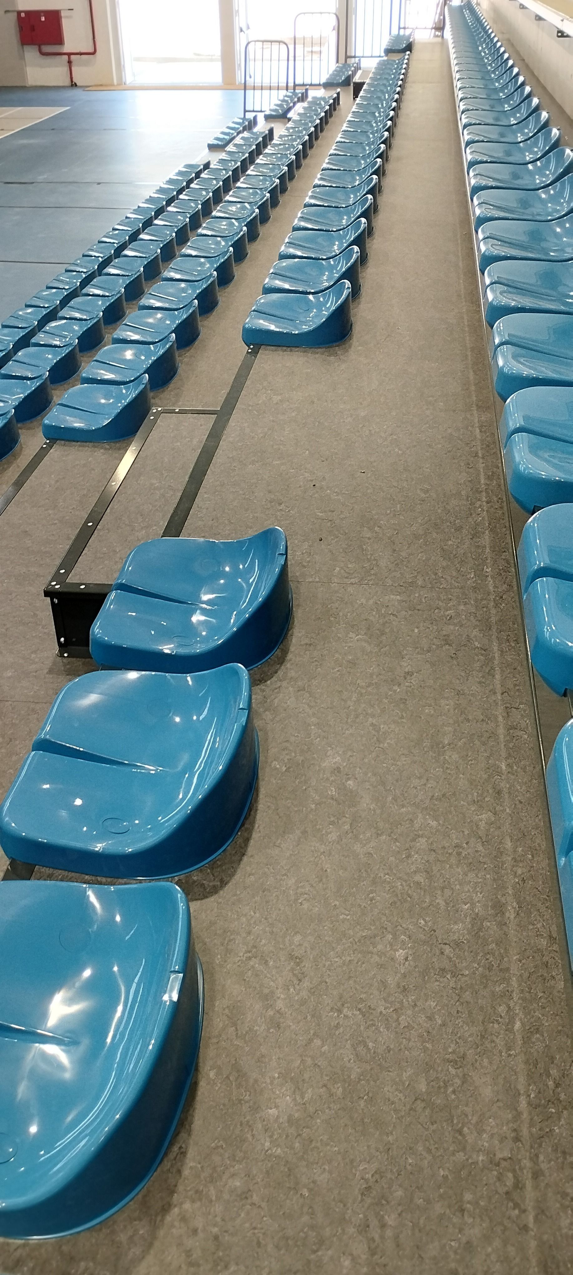 Una fila de asientos de plástico azul en un estadio.