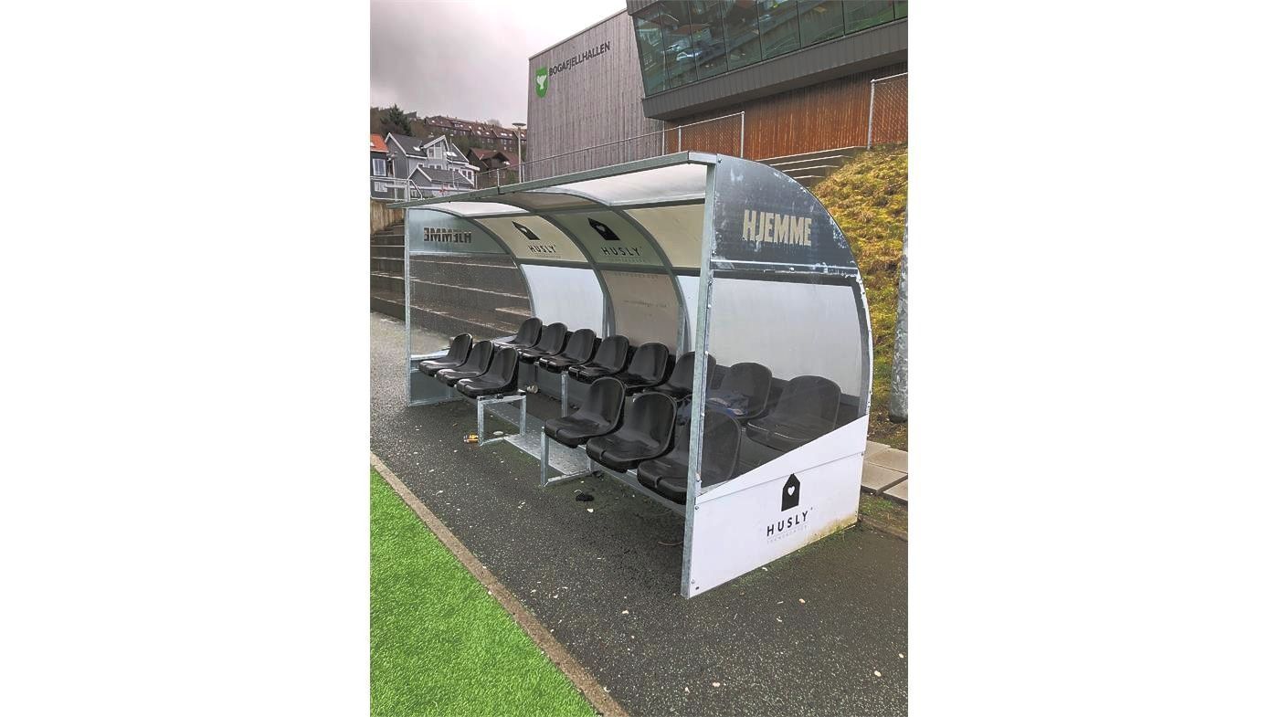 Un refugio de fútbol está sentado al costado de un campo de fútbol.