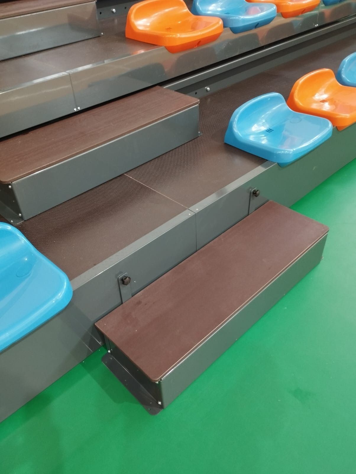 Una fila de gradas con asientos azules y naranjas