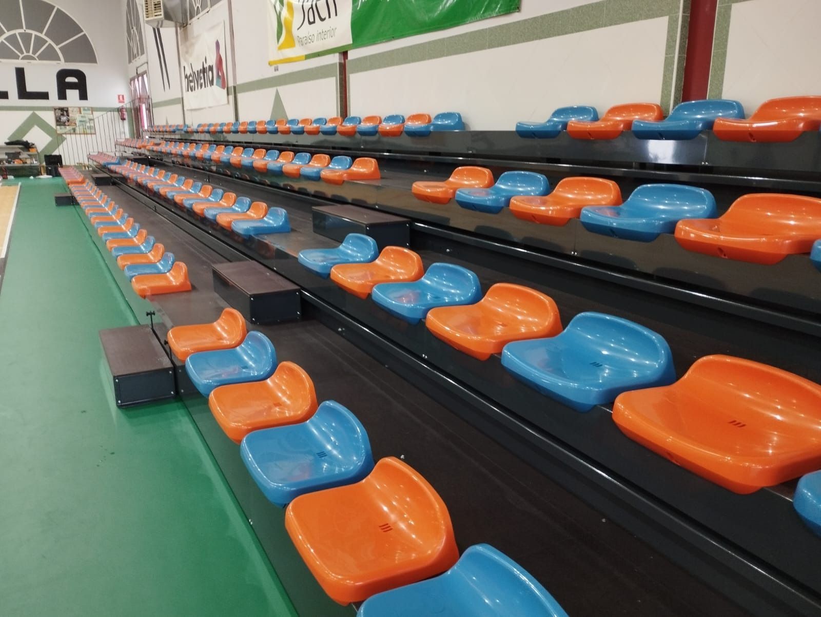 Una fila de asientos naranjas y azules en un estadio