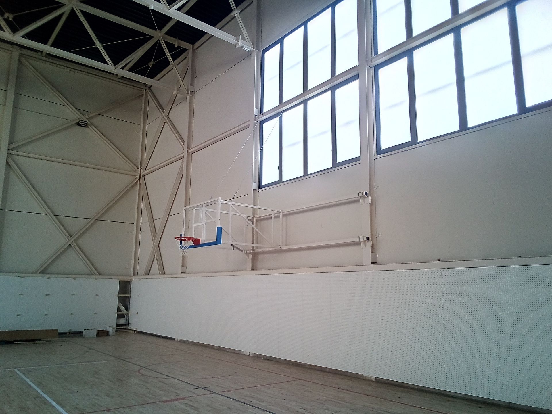 Una cancha de baloncesto vacía con un aro de baloncesto en la pared.