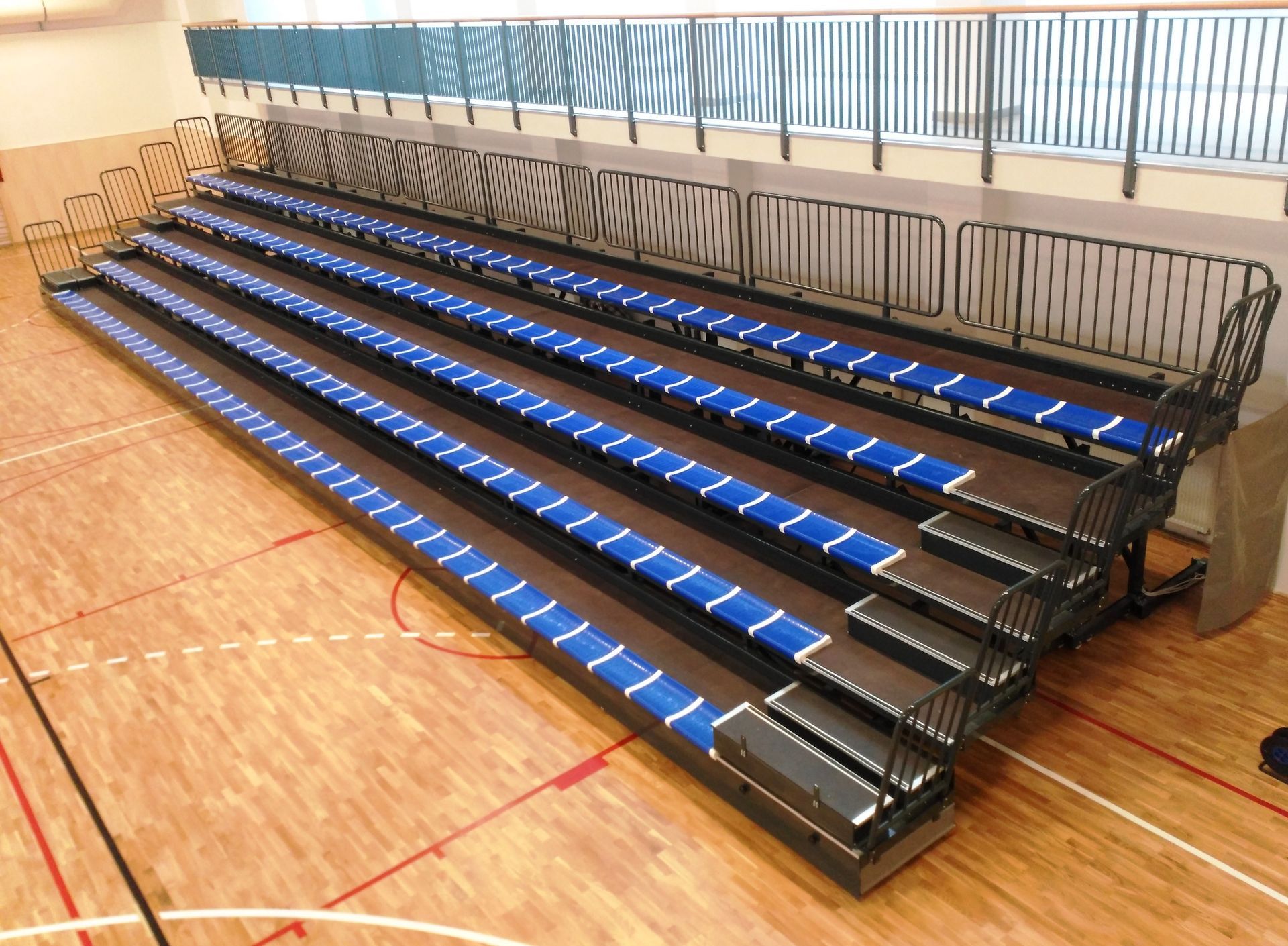 Una grada con asientos azules en una cancha de baloncesto.