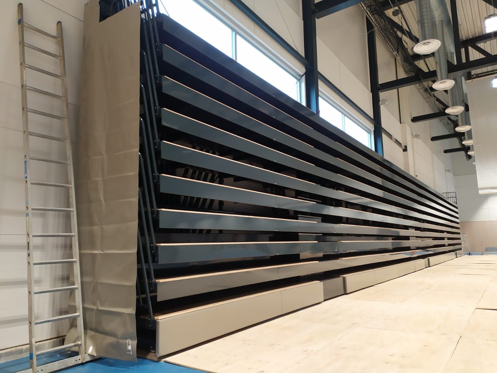 Una escalera está apoyada contra una pared en un gimnasio.