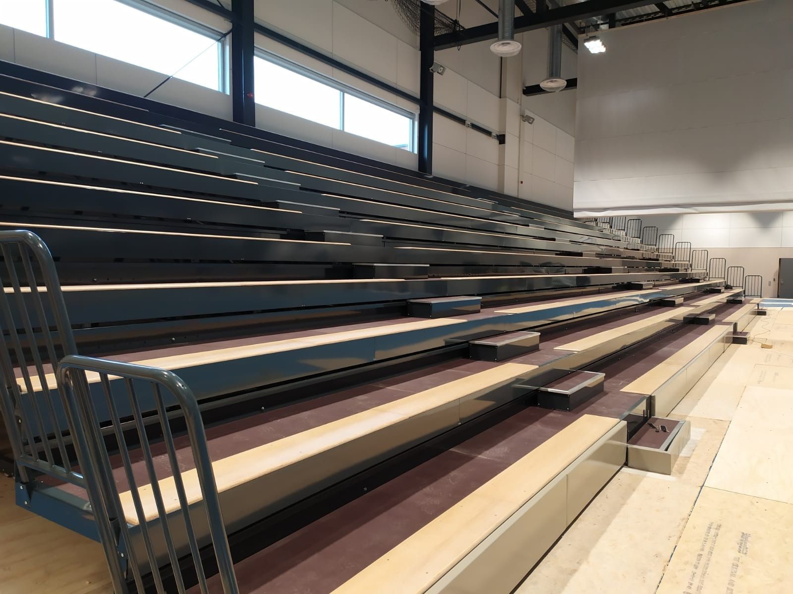 Una fila de gradas en un gimnasio con suelo de madera.