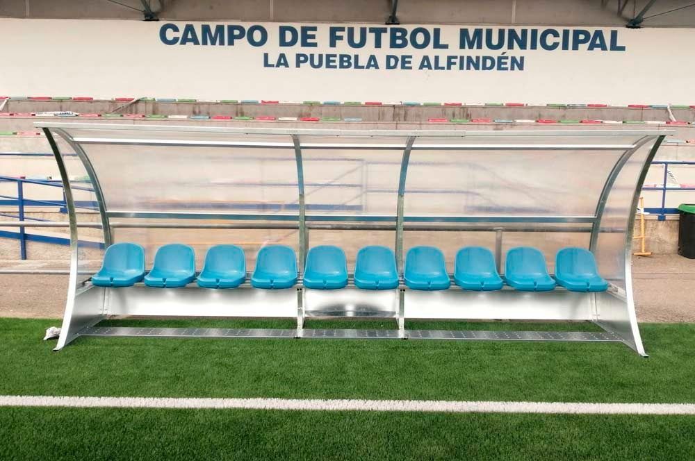 Un campo de fútbol con un refugio y un cartel que dice campo de fútbol municipal