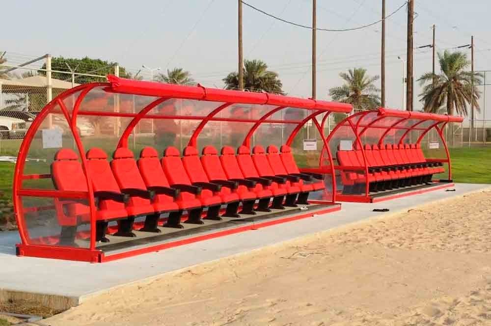 Una fila de asientos rojos bajo un techo transparente