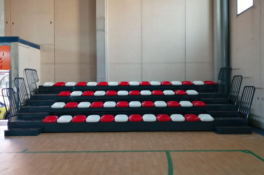 Una fila de asientos rojos y blancos en un gimnasio