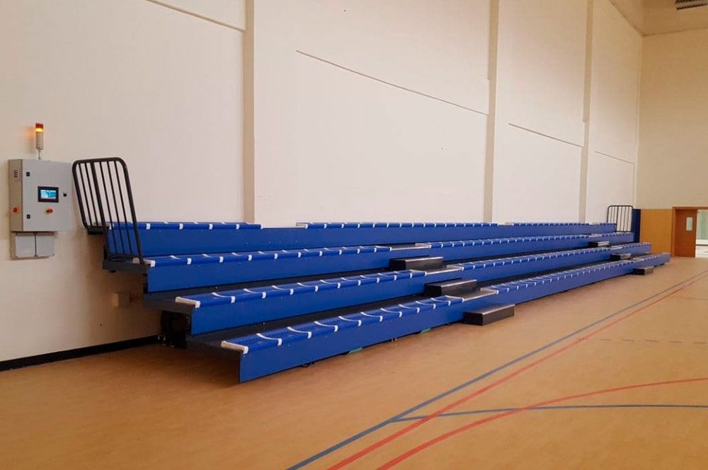 Una fila de gradas azules en un gimnasio vacío