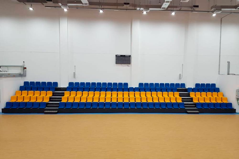 Una fila de asientos azules y amarillos en un gimnasio