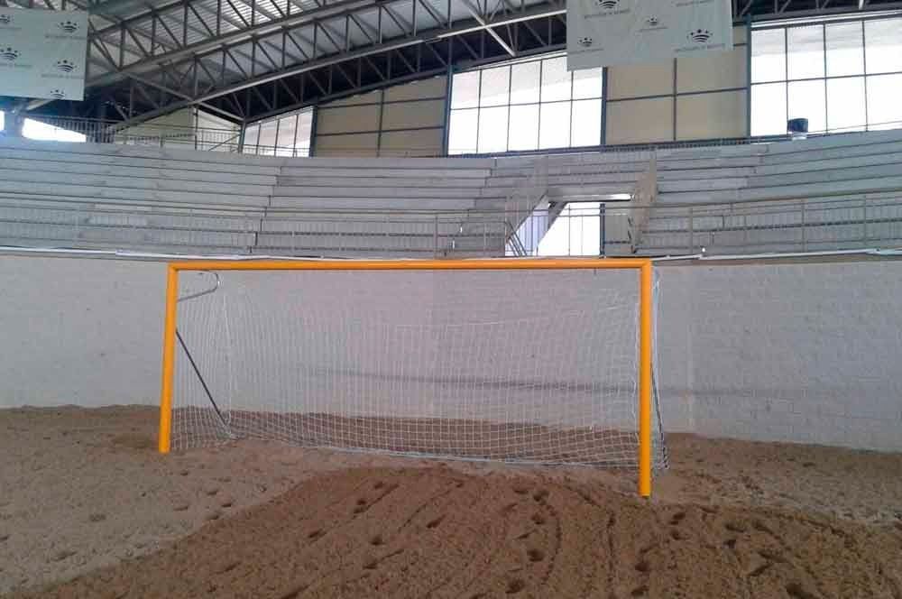 Una portería de fútbol en un estadio con gradas al fondo