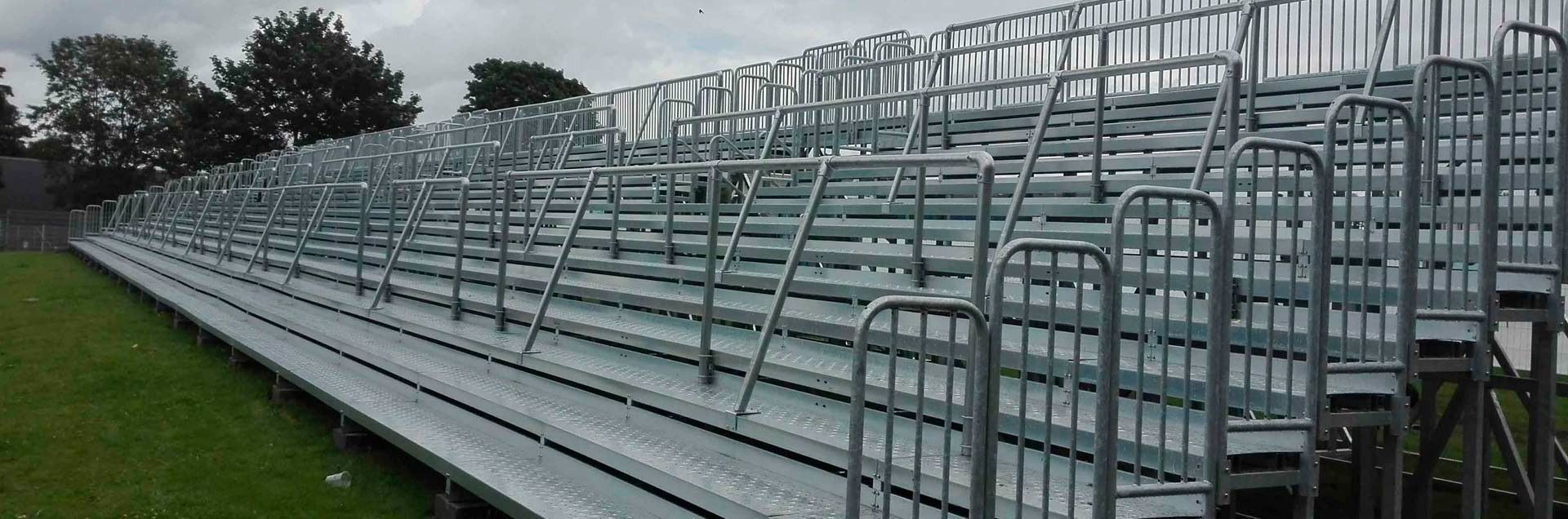 Una fila de gradas de metal situadas encima de un exuberante campo verde.