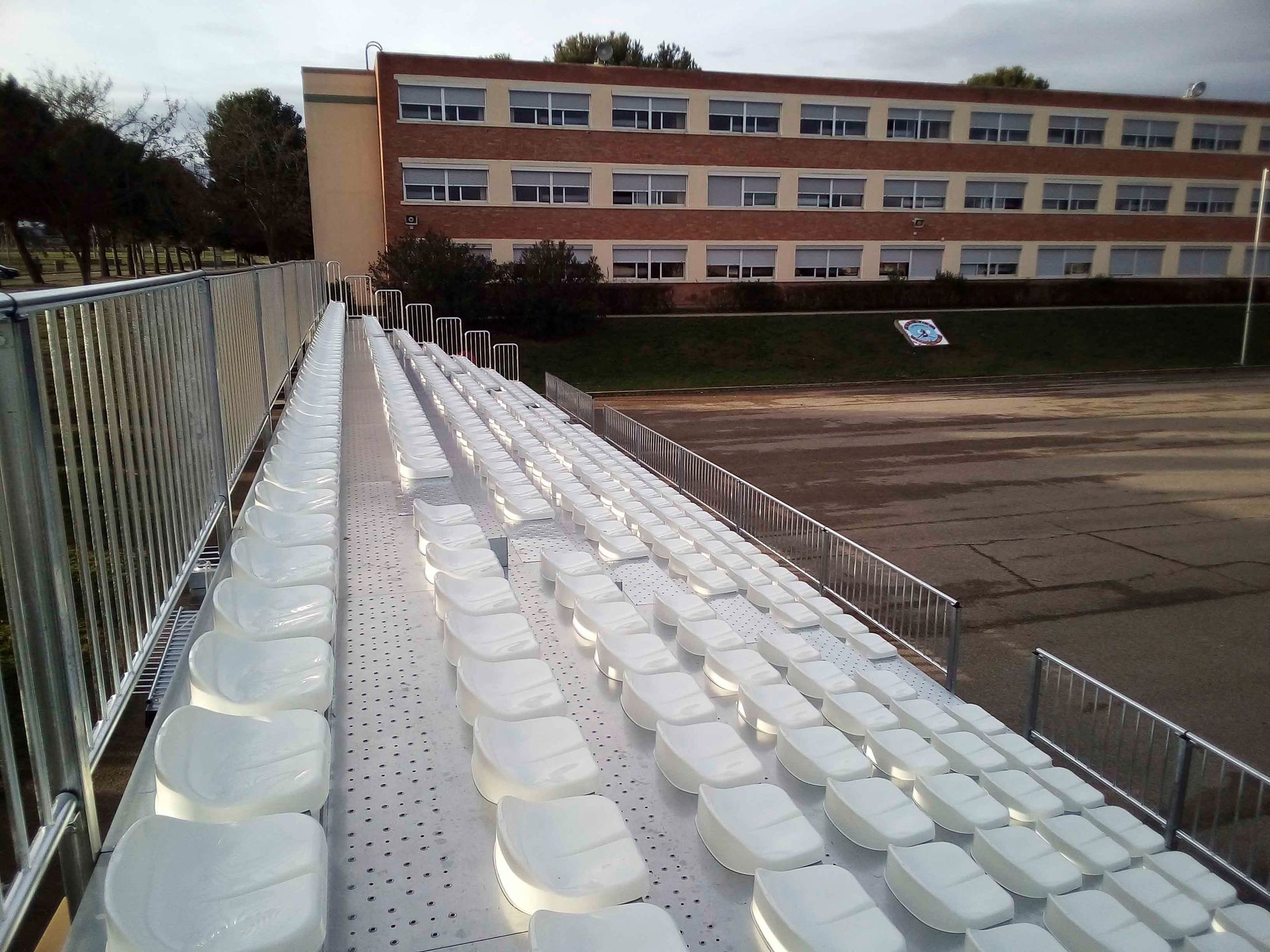 Una fila de asientos blancos frente a un gran edificio.