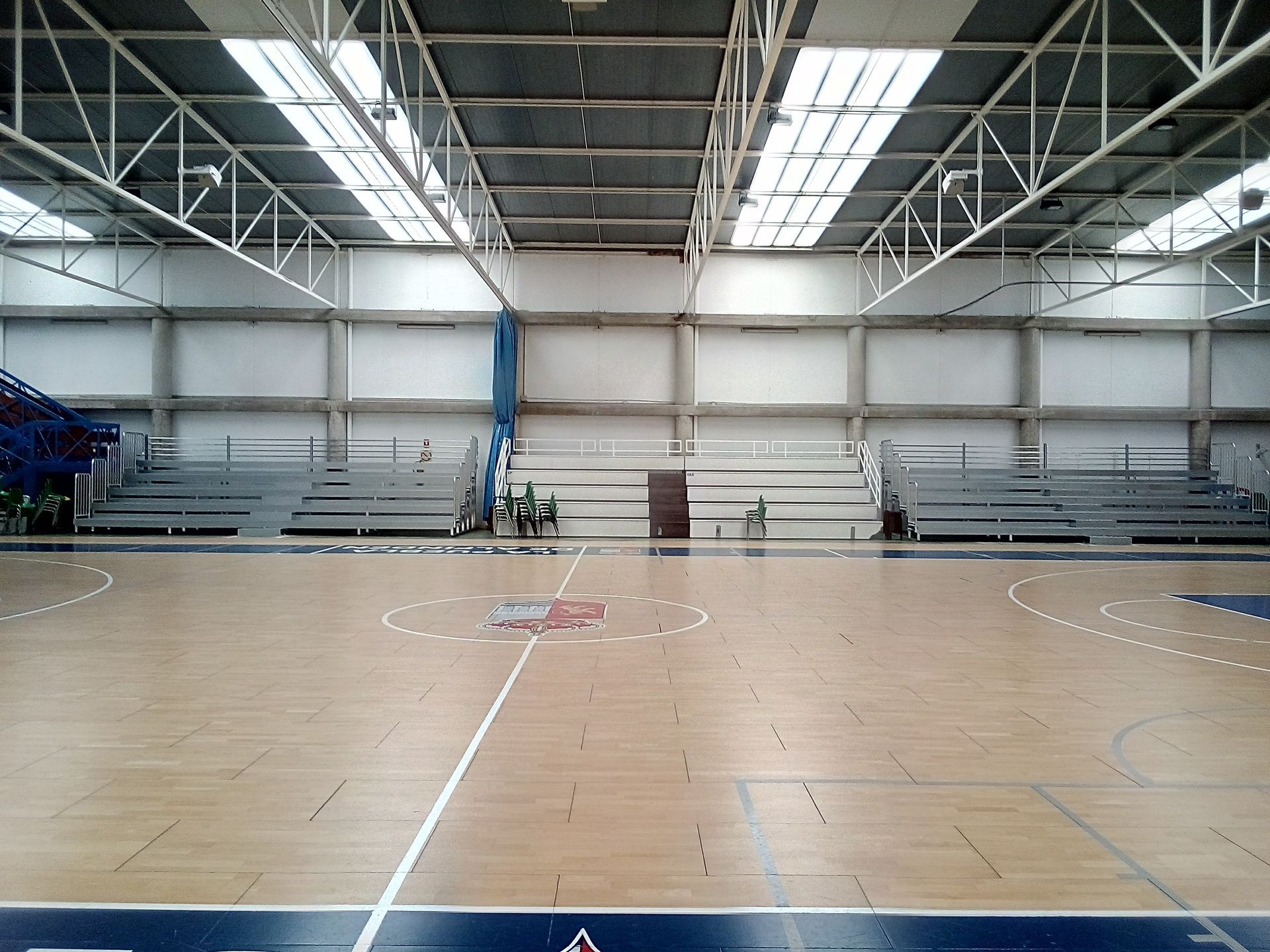 Una cancha de baloncesto vacía con gradas al fondo