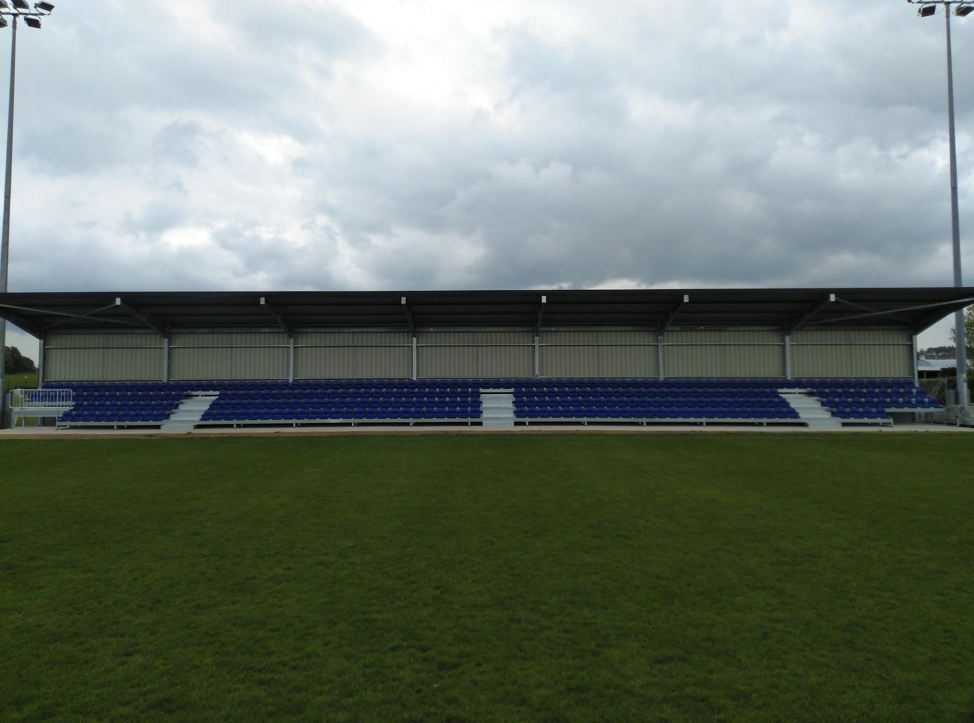 Un estadio con asientos azules y techo blanco