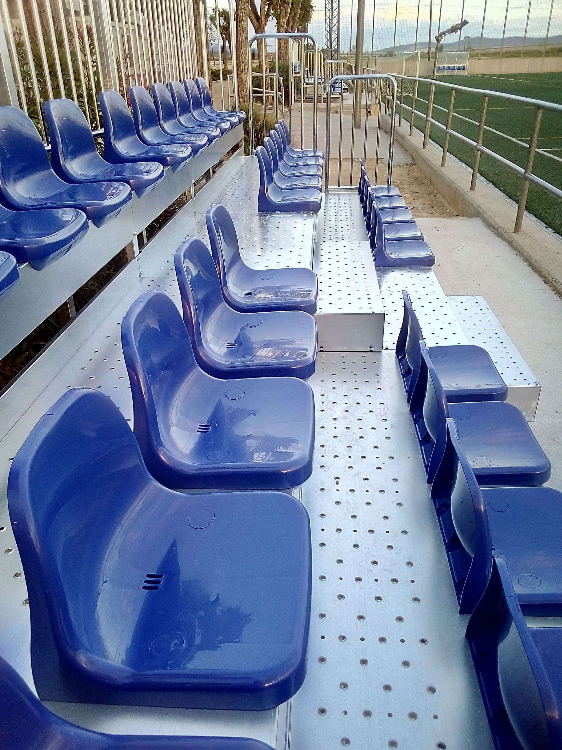 Filas de asientos azules están alineadas en un estadio