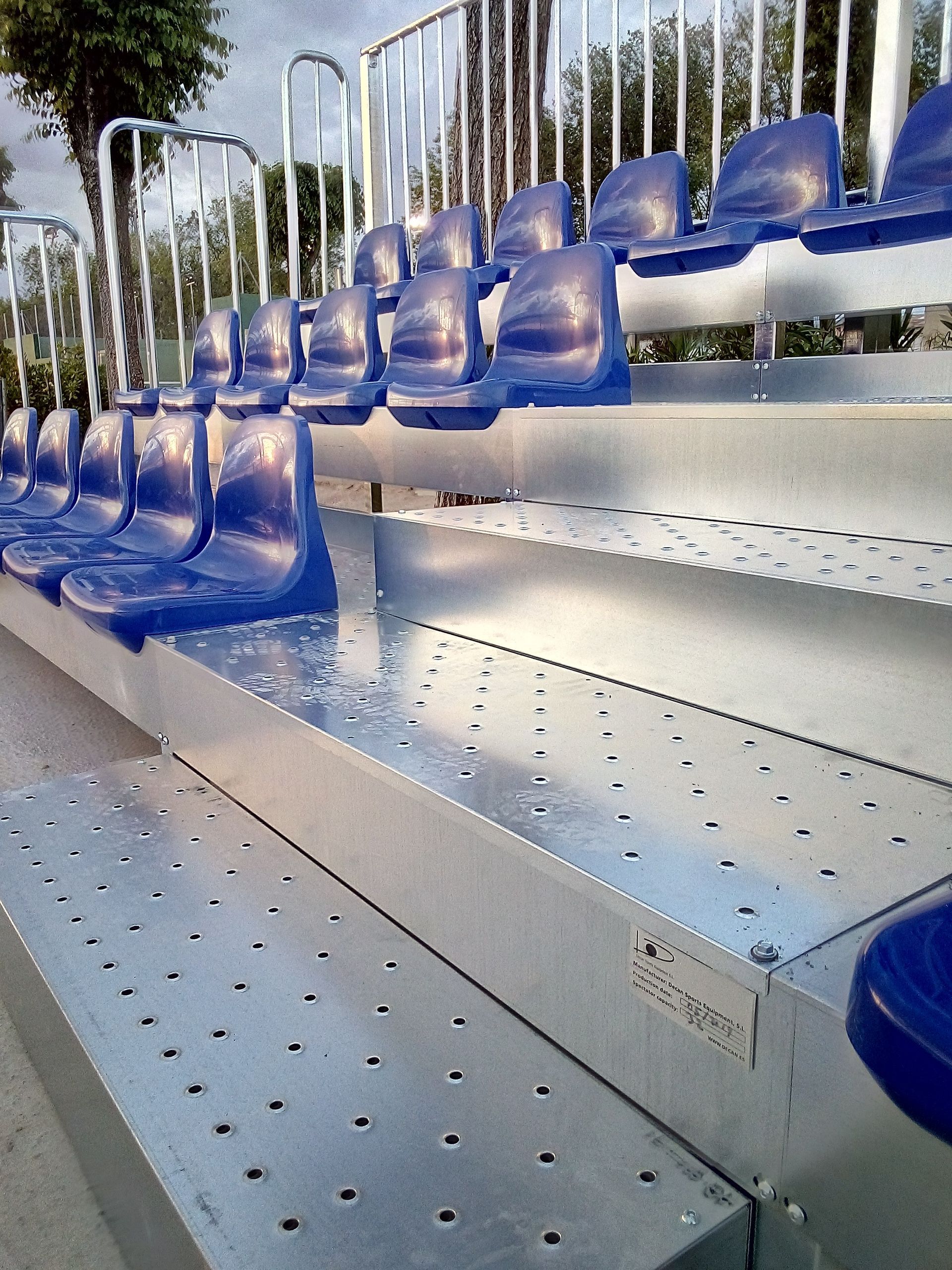 Una fila de asientos azules en una grada de metal