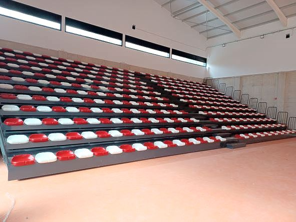 Una fila de asientos rojos y blancos en un estadio