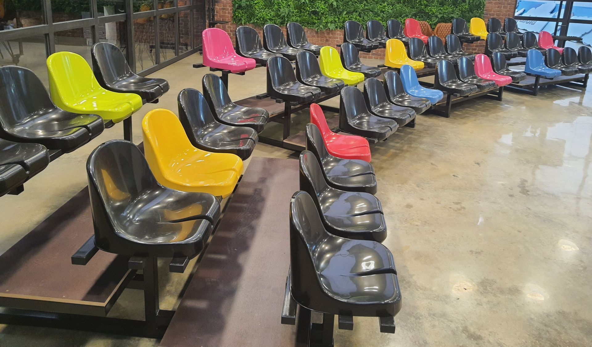 Una fila de sillas de colores están alineadas en un estadio.