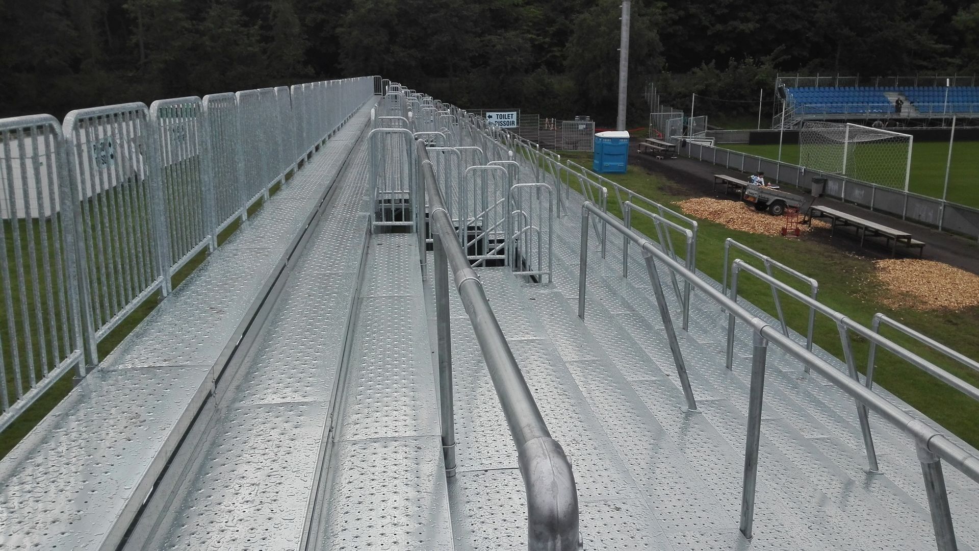 Un estadio con gradas y una valla que lo rodea.
