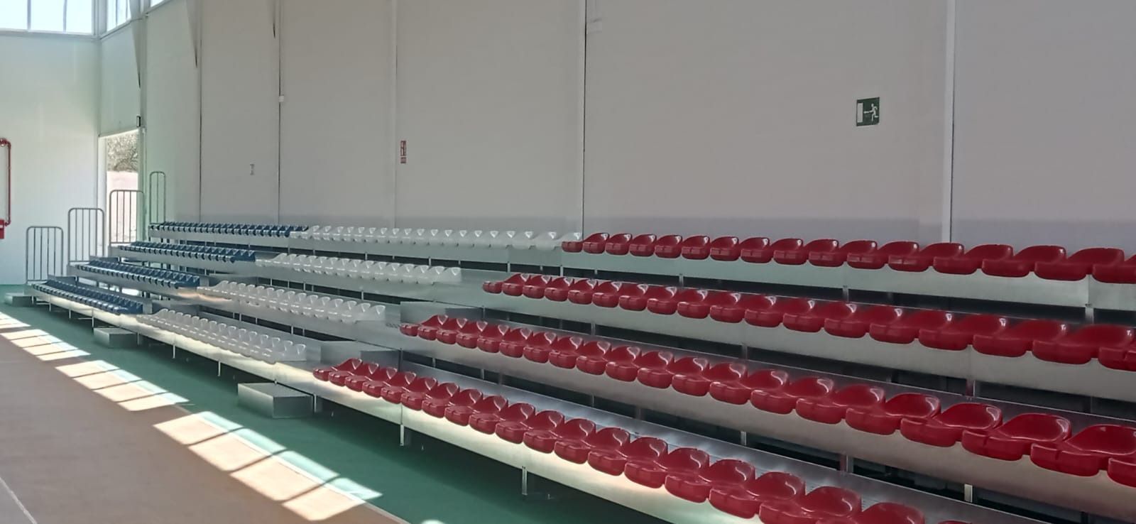 Una fila de gradas con asientos rojos y blancos