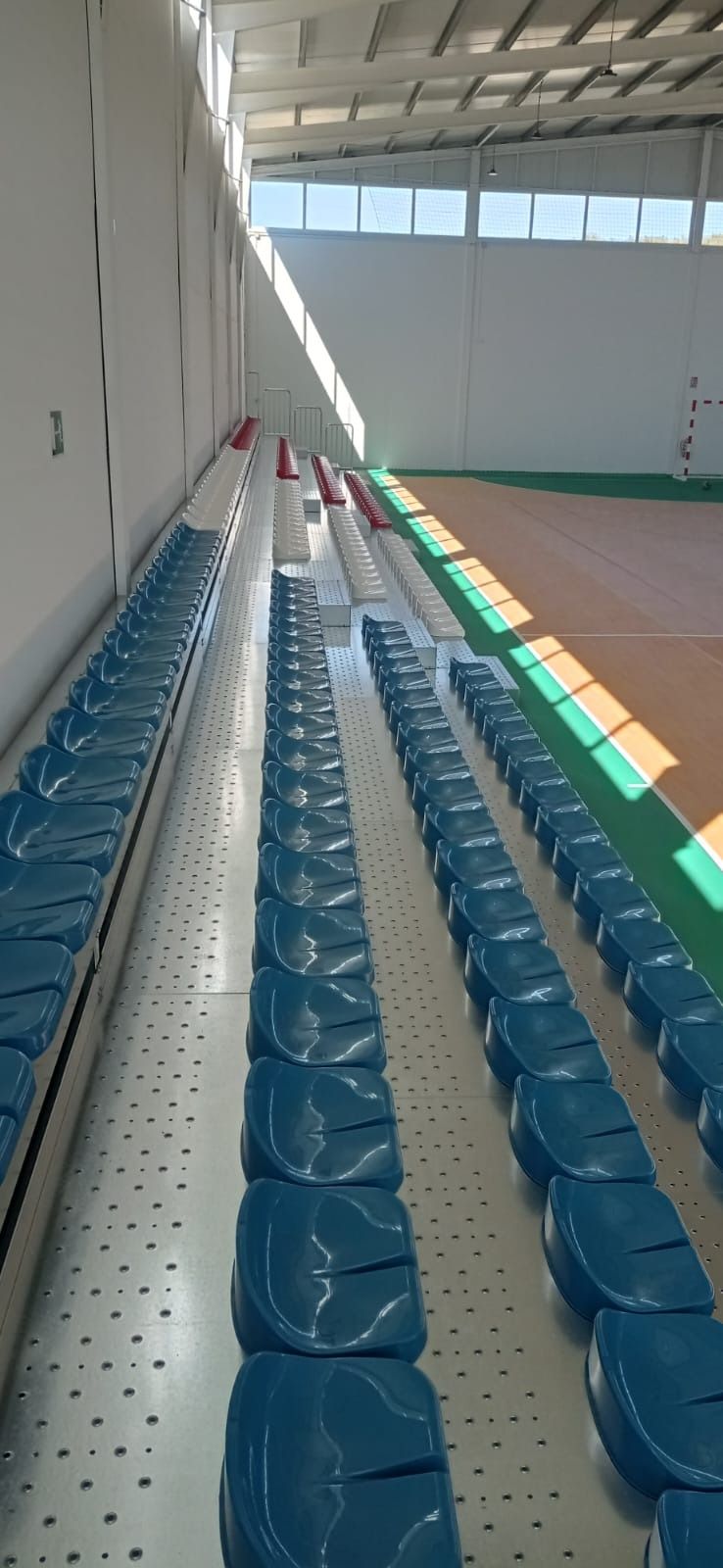 Una fila de asientos azules están alineados en un estadio