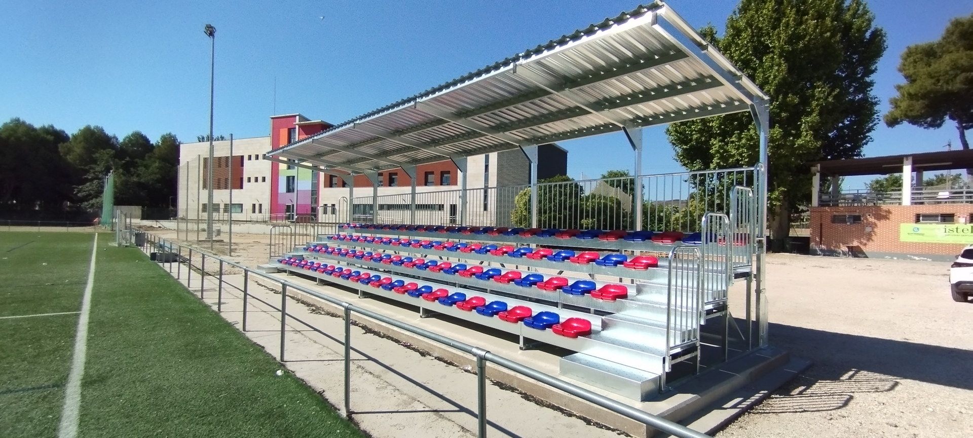 Una fila de gradas en un campo de fútbol con un edificio al fondo