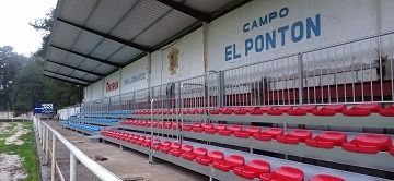 Un estadio con asientos rojos y un cartel que dice campo el ponton