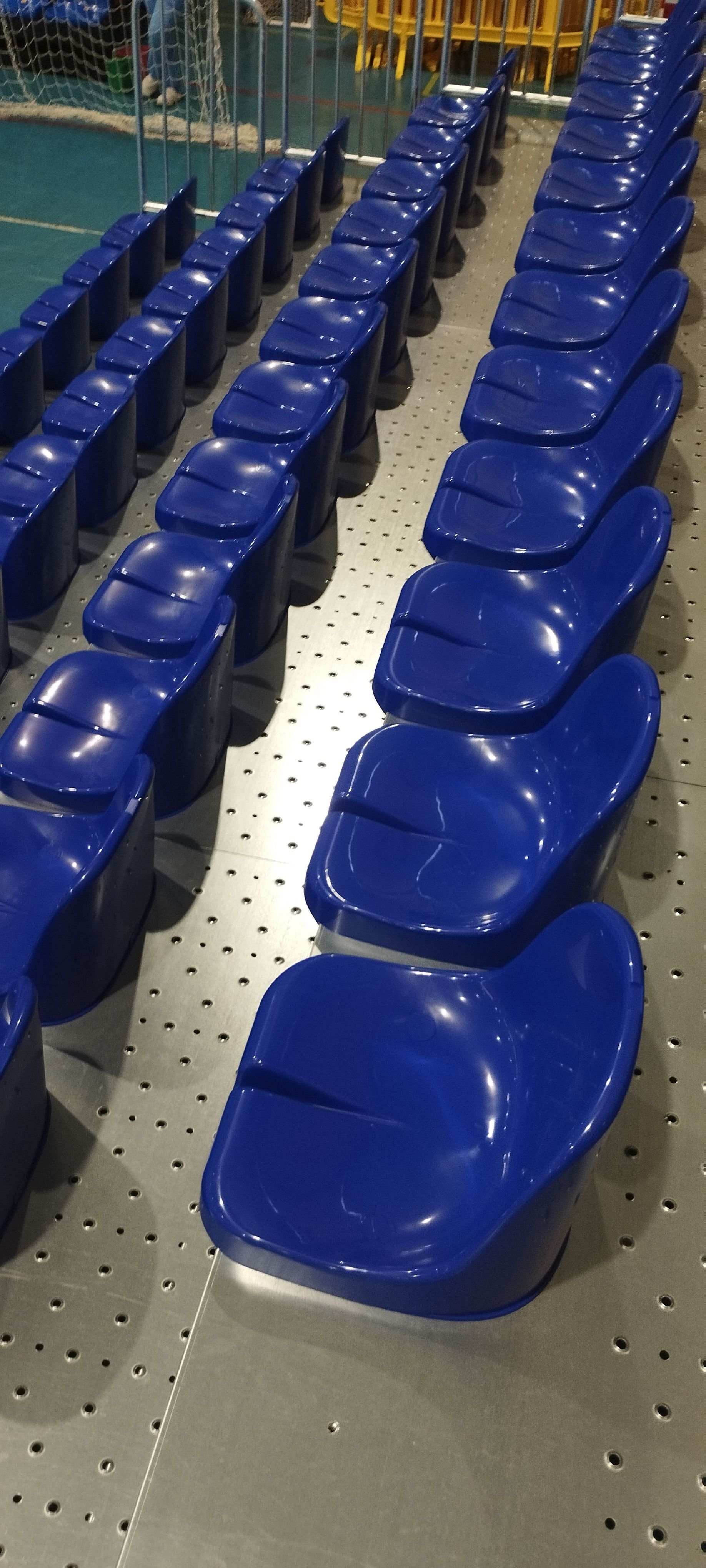 Una fila de asientos de plástico azul en un estadio.