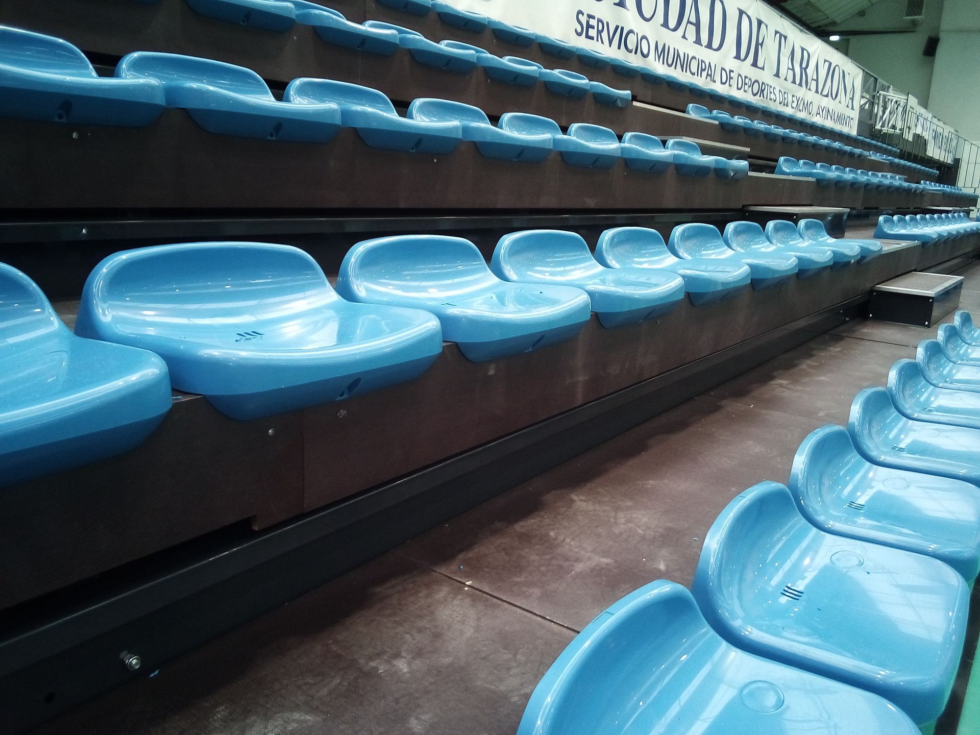 Una fila de asientos azules en un estadio vacío