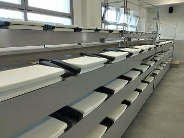 Una larga fila de asientos blancos en un estadio