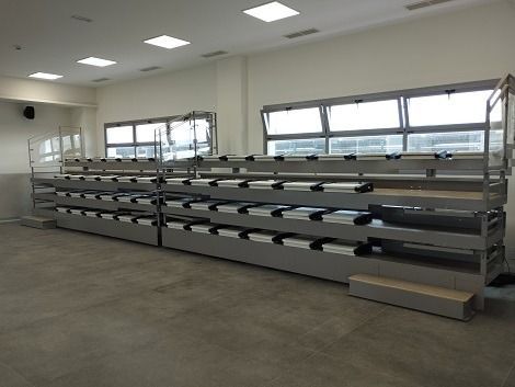 Una fila de gradas en una sala grande con muchas ventanas.