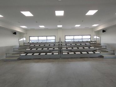 Una gran sala vacía con filas de gradas en ella.