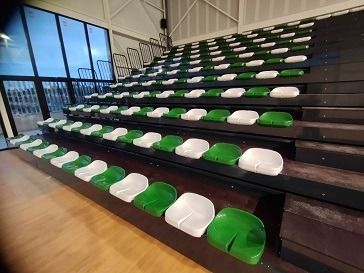 Una fila de asientos verdes y blancos en un estadio.