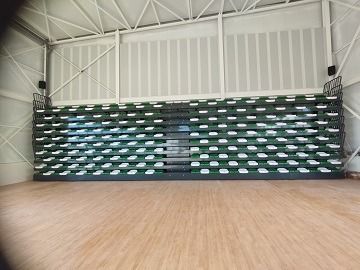 Una fila de gradas en un gimnasio con suelo de madera.