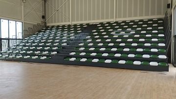 Una fila de gradas en un gimnasio con suelo de madera.