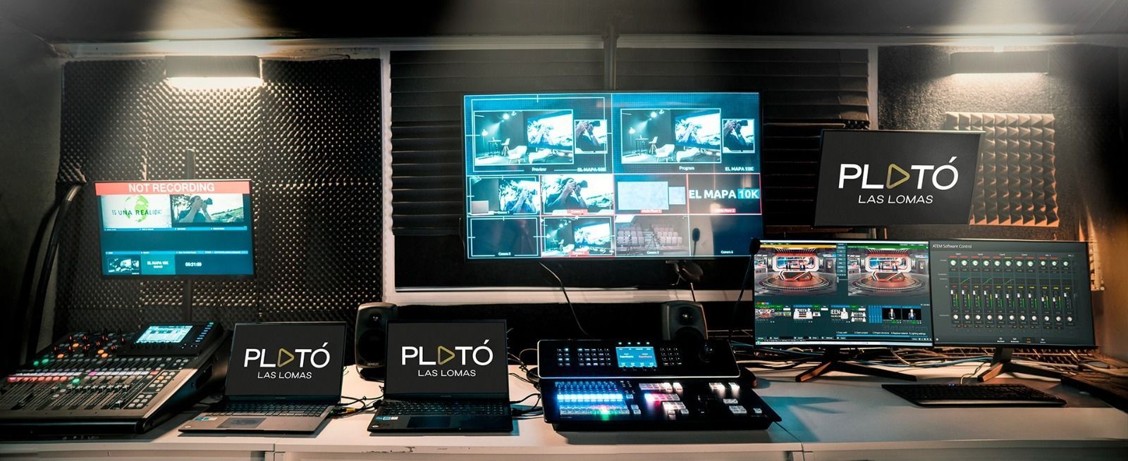 Una habitación con muchos monitores de computadora y un cartel que dice Plutón.