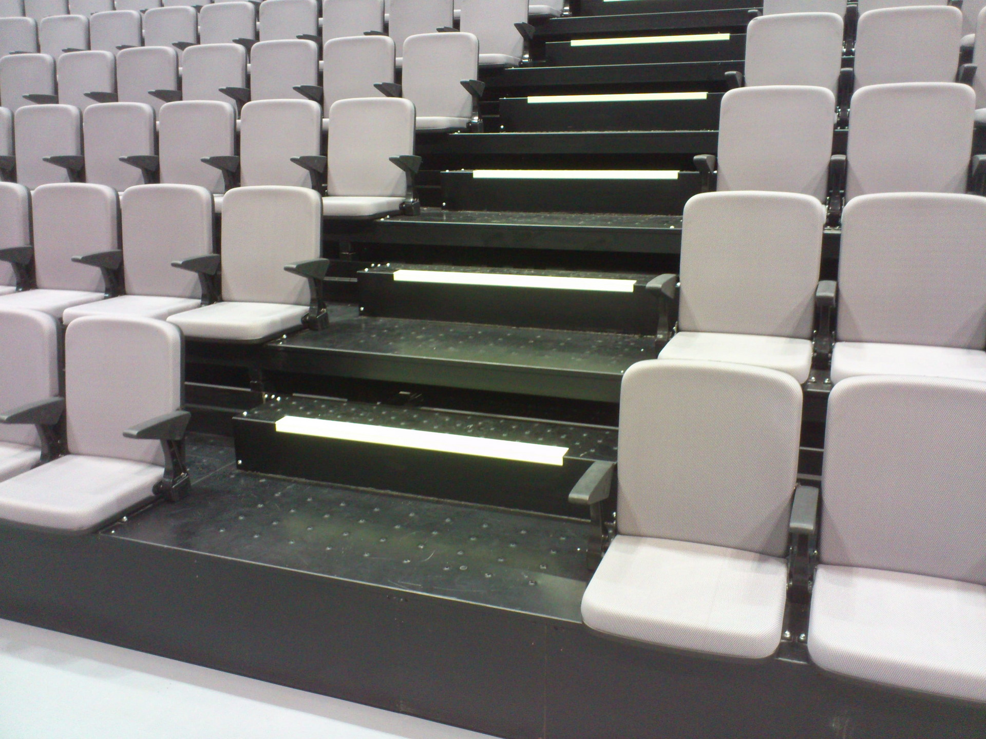 Una fila de asientos en un auditorio con escaleras que conducen a ellos.