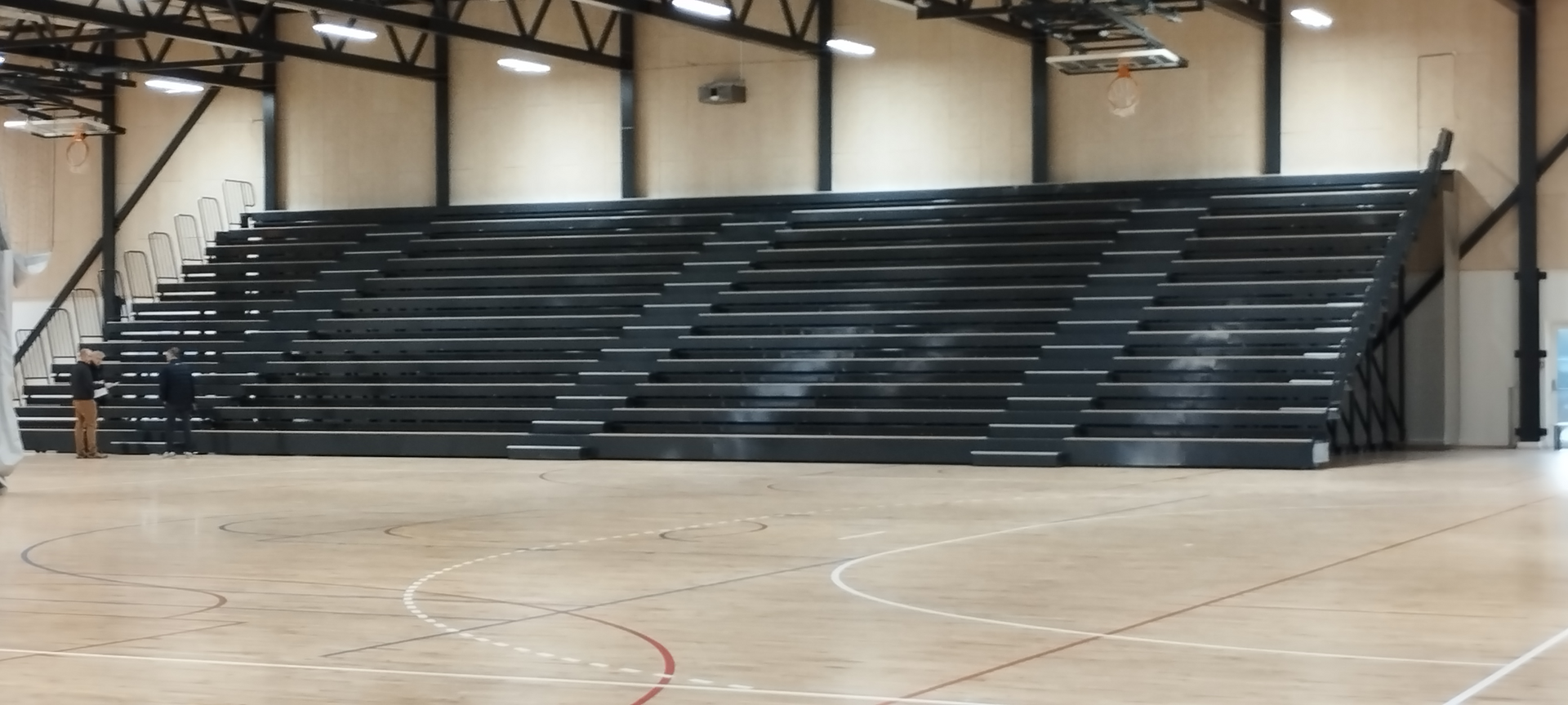 Una cancha de baloncesto con una grada en el medio.