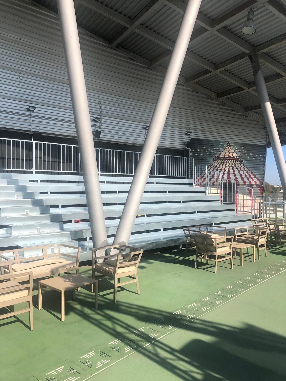 Un estadio con mesas y sillas bajo techo.