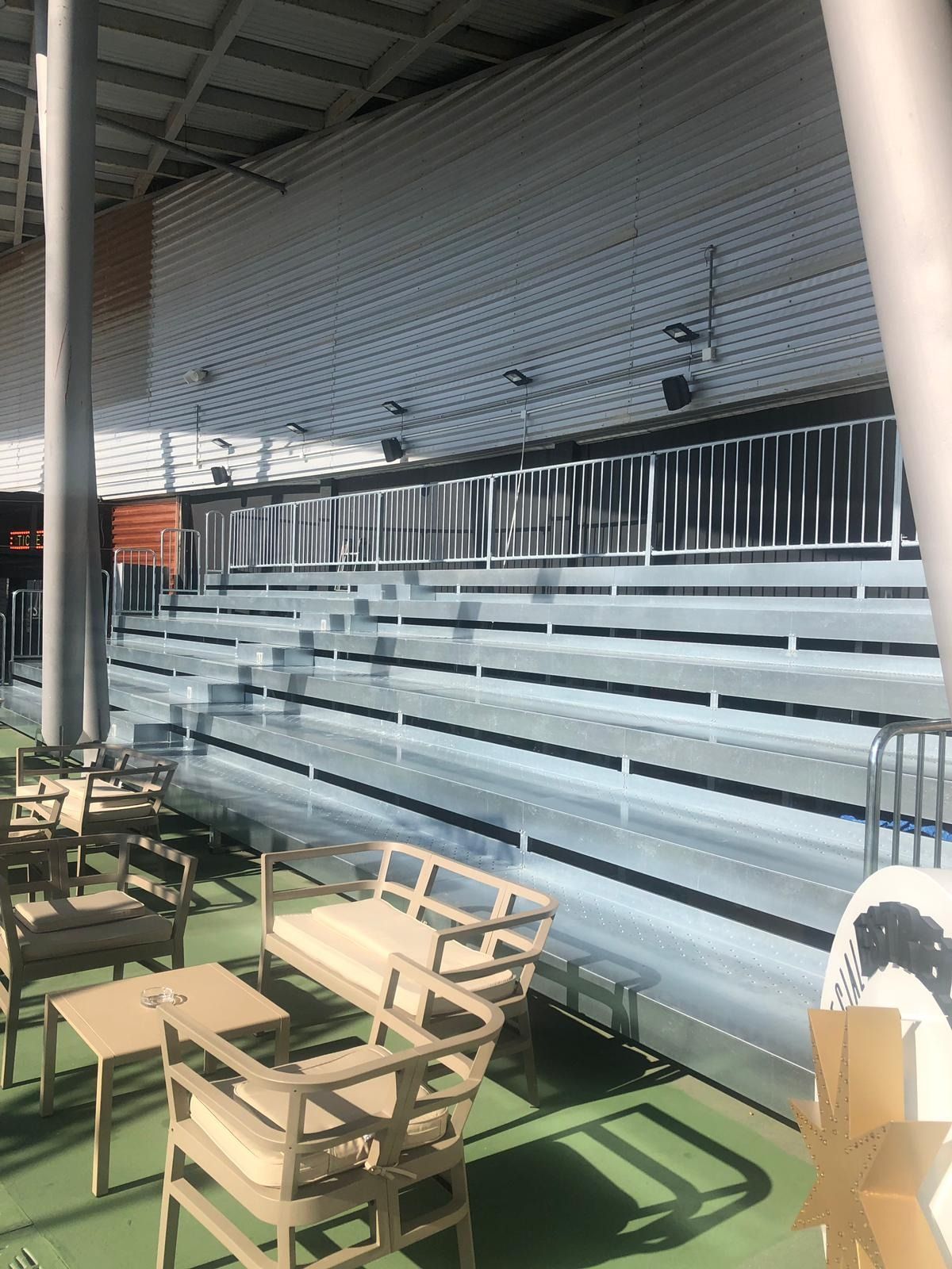 Una fila de gradas con sillas y mesas delante de ellas.