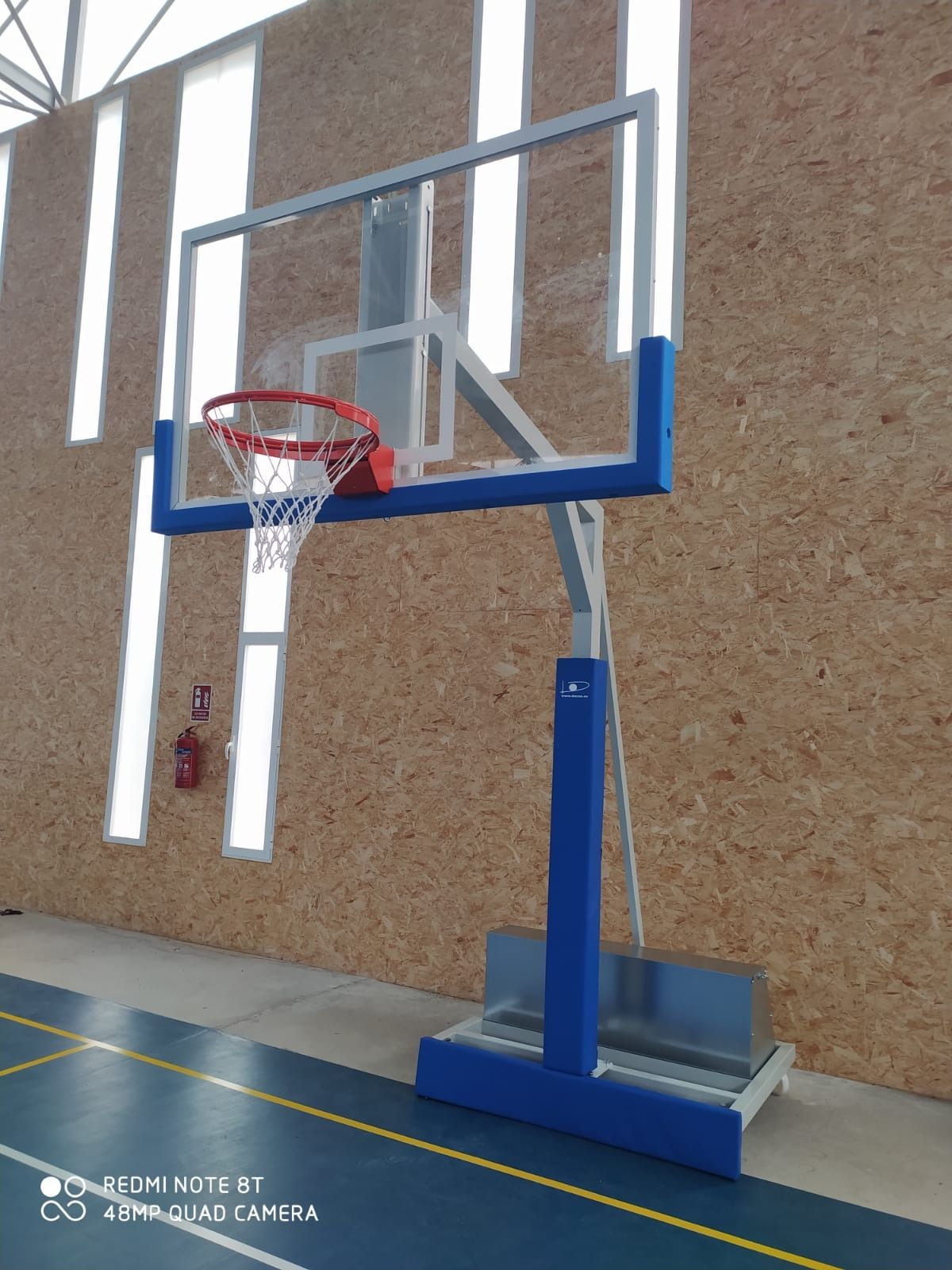 Un aro de baloncesto está en el medio de un gimnasio.