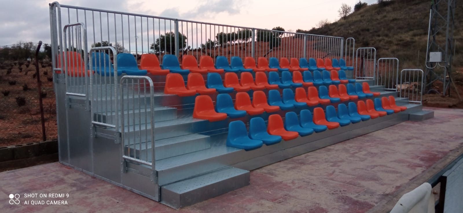 Un estadio con asientos y escaleras azules y naranjas.