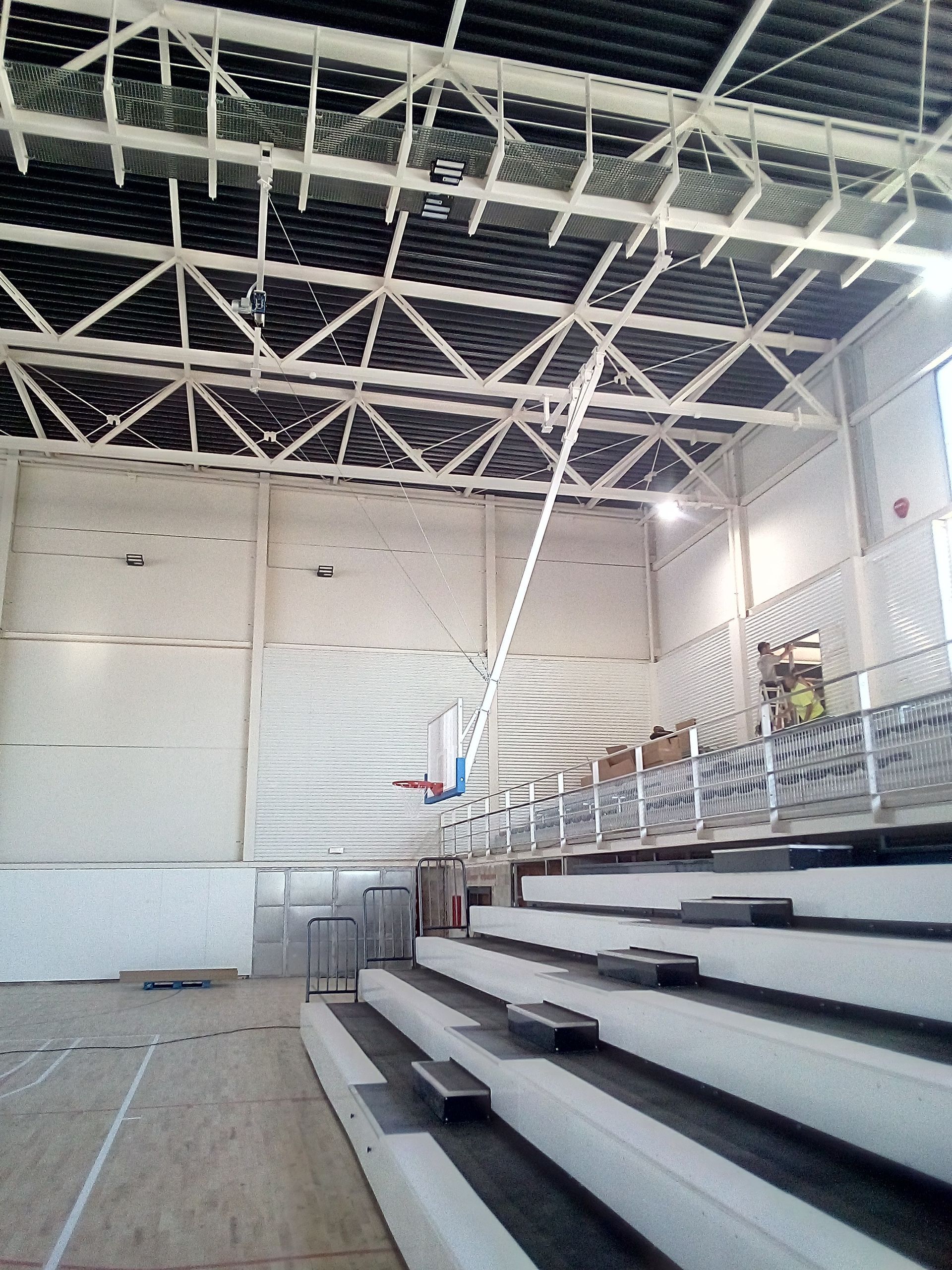 Un gran estadio cubierto con gradas y un aro de baloncesto.