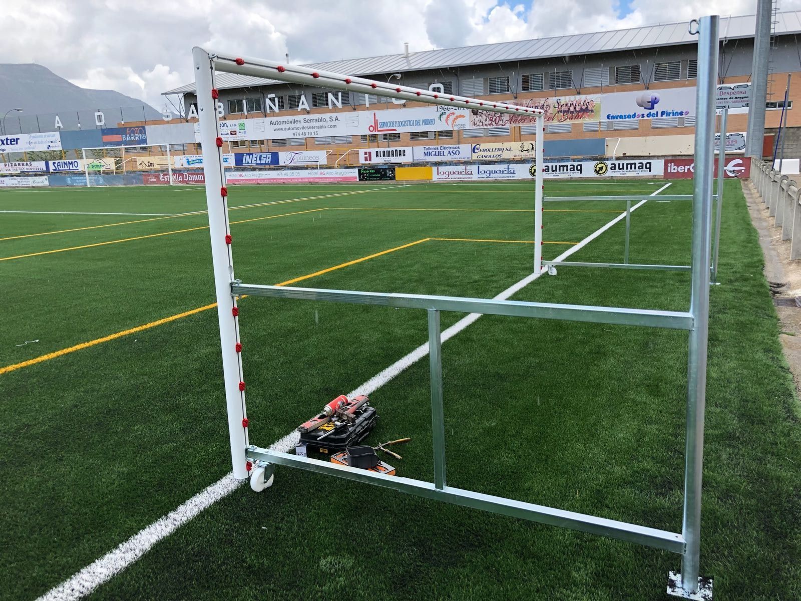 Una portería de fútbol está situada al costado de un campo de fútbol.