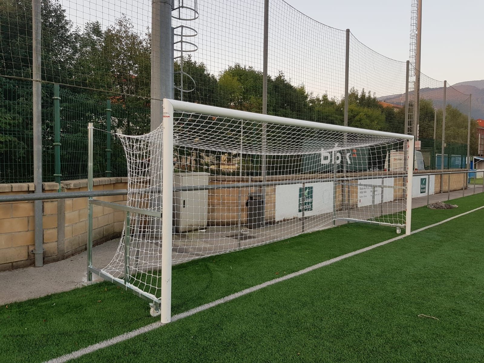 Una portería de fútbol en un campo con una valla alrededor.