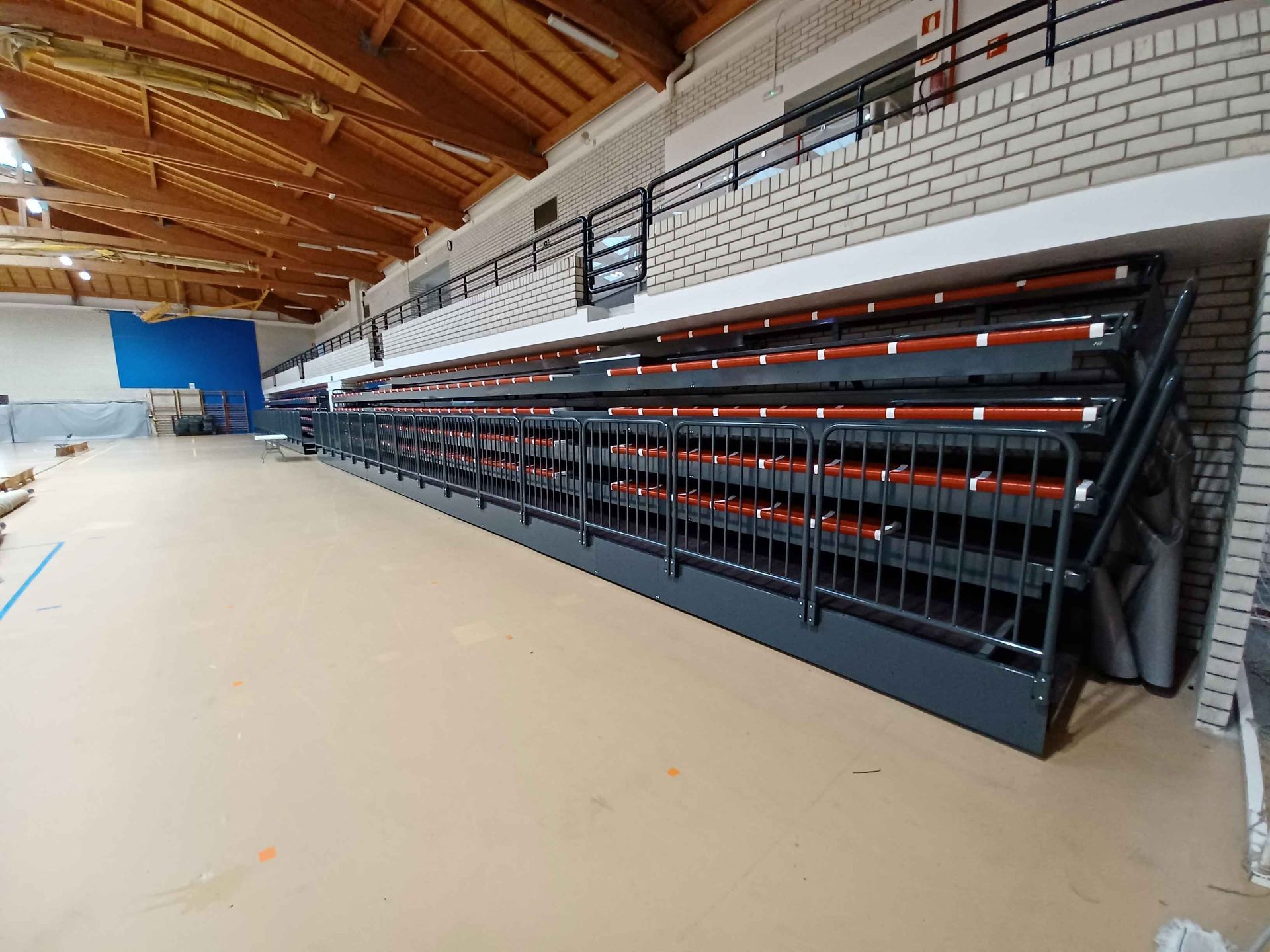 Una larga fila de gradas en un gimnasio con escaleras que conducen a ellas.